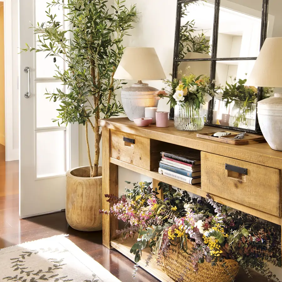 recibidor con mueble de madera rústica con espejo, olivo y flores secas, lámparas de mesa y jarrón de cristal